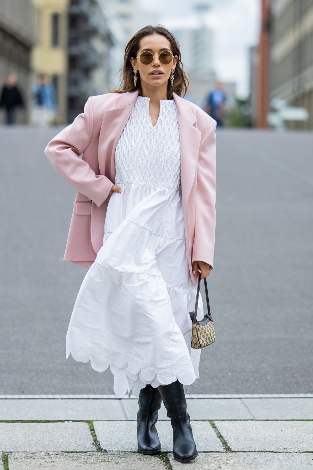 Woman wearing white dress pink blazer and boots GettyImages-2160626664