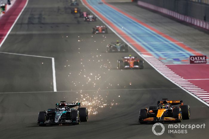 George Russell, Mercedes F1 W15, trails sparks as he battles with Oscar Piastri, McLaren MCL38