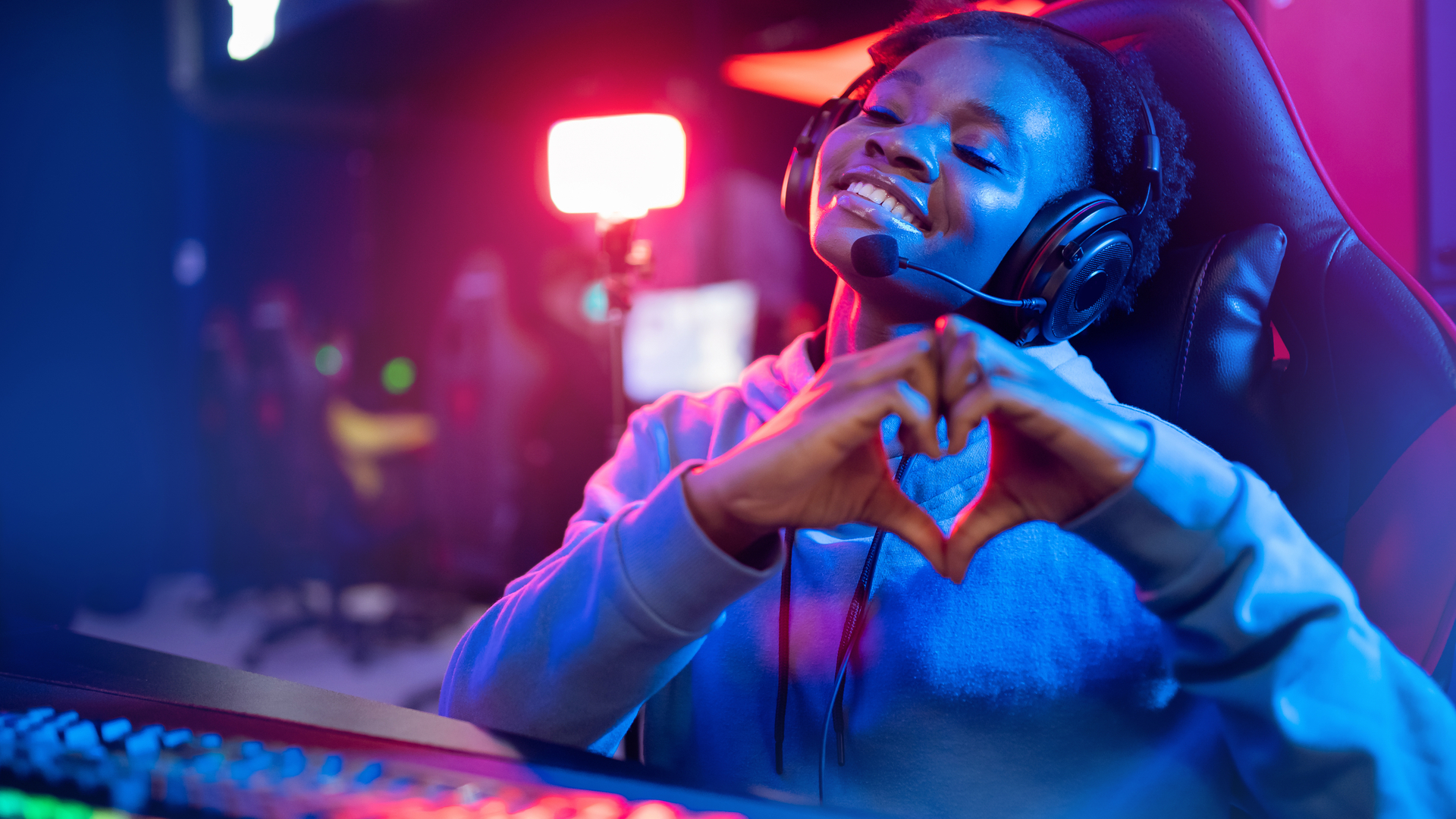 Happy PC gamer shows heart sign with hands