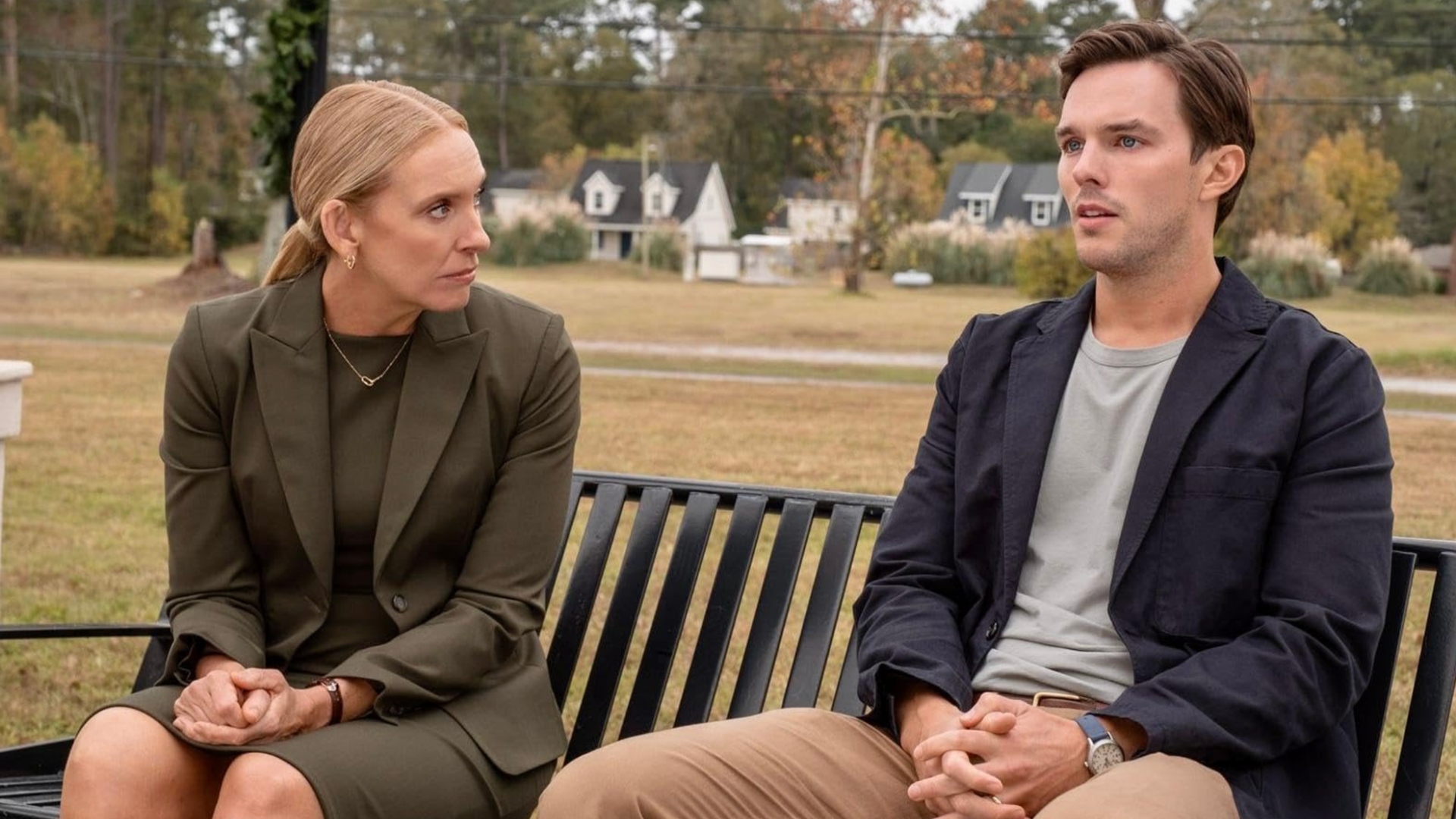 Nicholas Hoult and Toni Collette sit on a bench