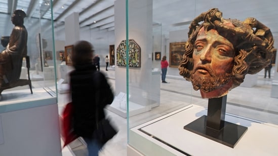 A journalist walks past the "Head of Christ crowned with thorns" (R), from the chapel of Notre Dame de l'Echerelle-Troyes, during a press visit of the renewed Time Gallery at the Louvre-Lens (AFP)