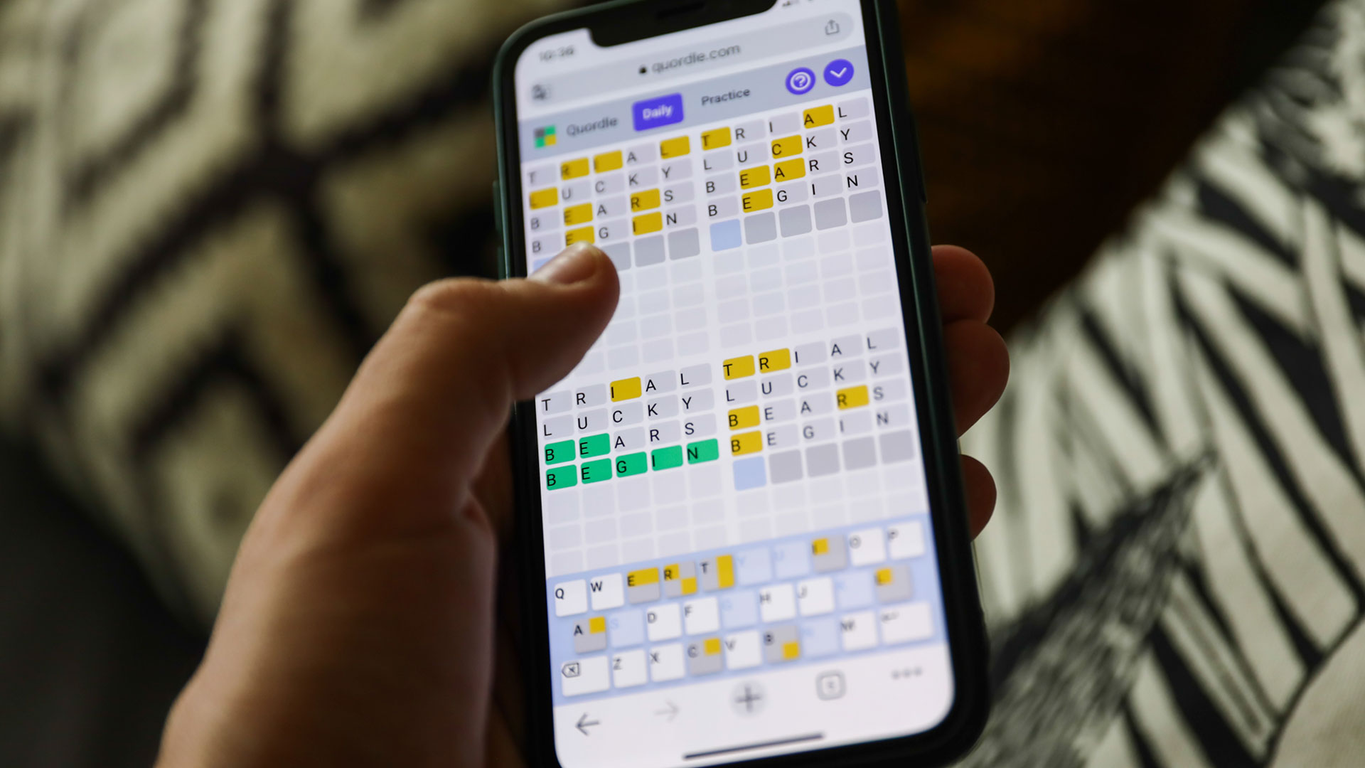 Quordle on a smartphone held in a hand