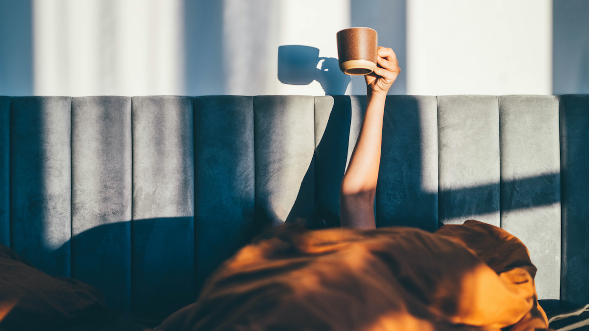 Person in raises a coffee cup to the sky