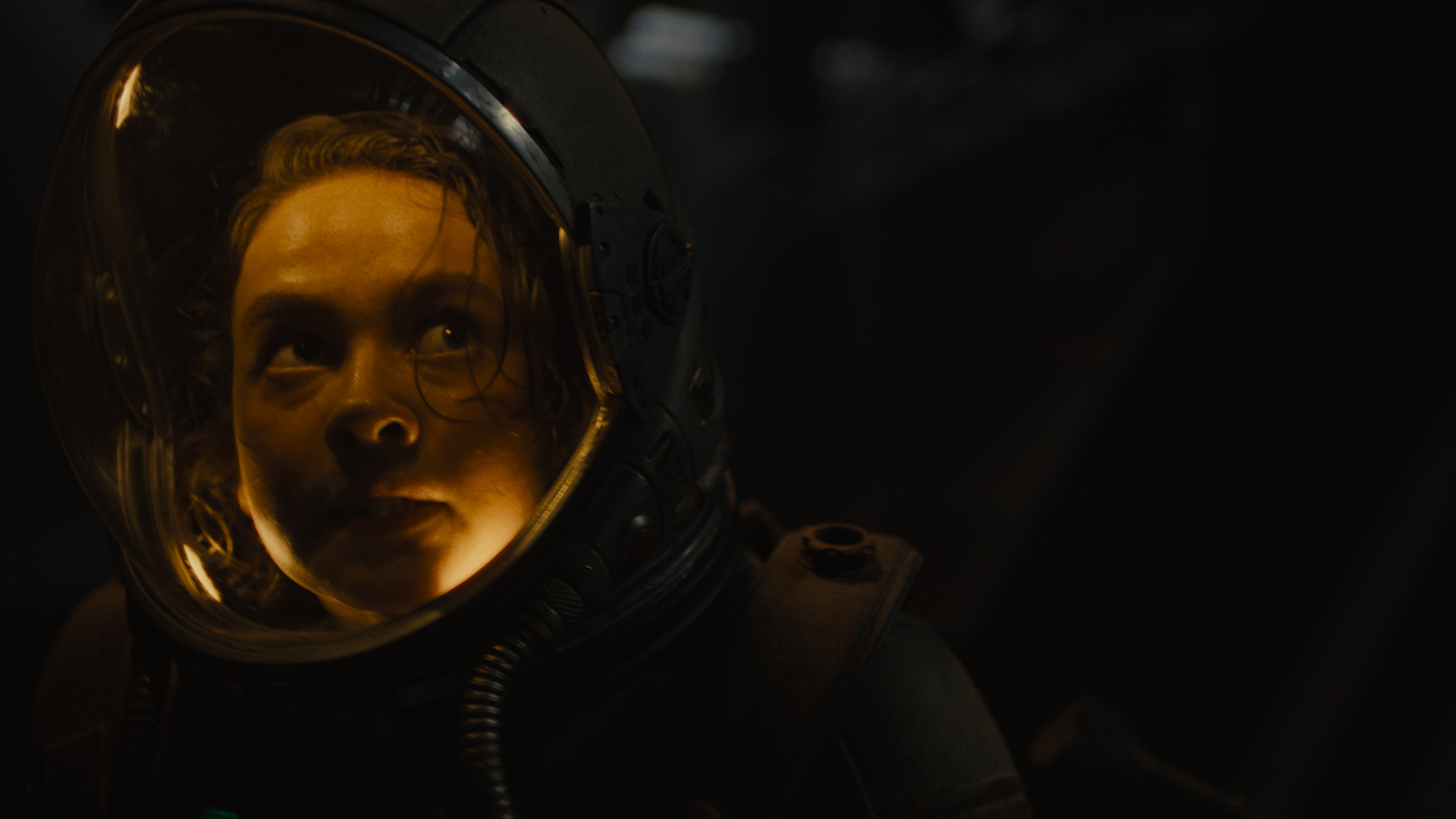 Rain looks behind her in her spacesuit in Alien: Romulus