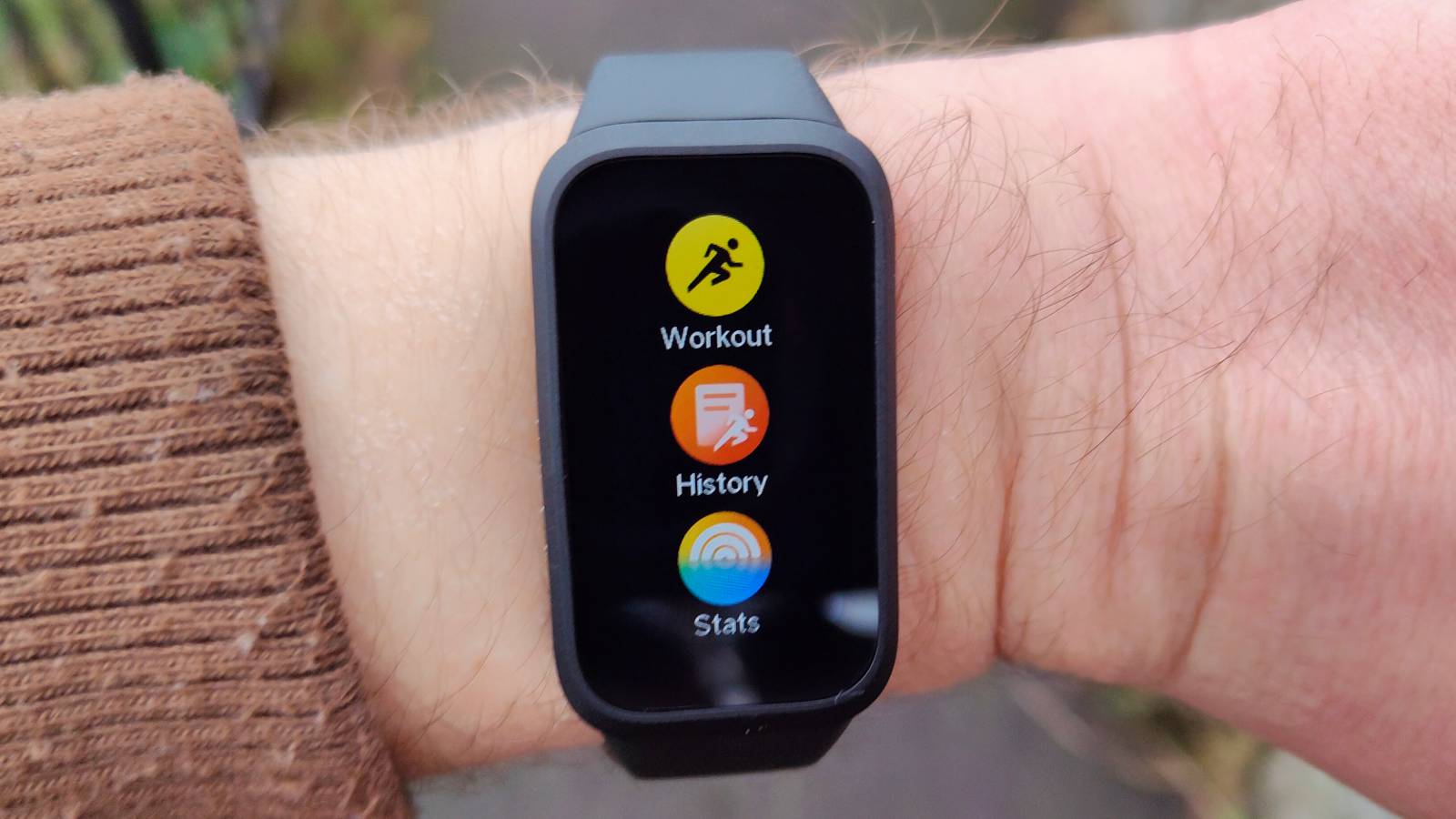 The Xiaomi Smart Band 9 Active being worn in a park.