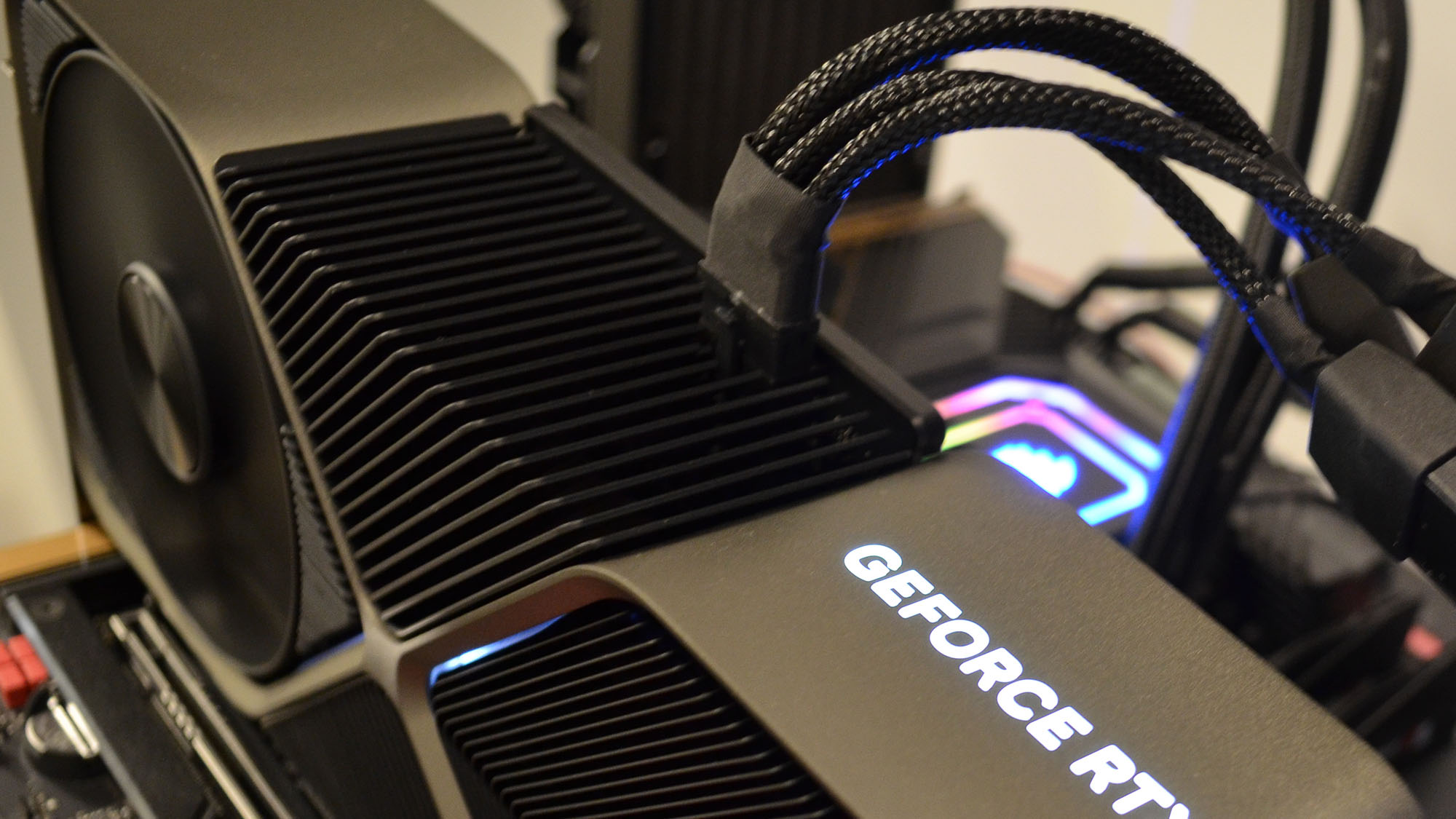 An Nvidia GeForce RTX 4080 on a wooden desk in front of a white panel