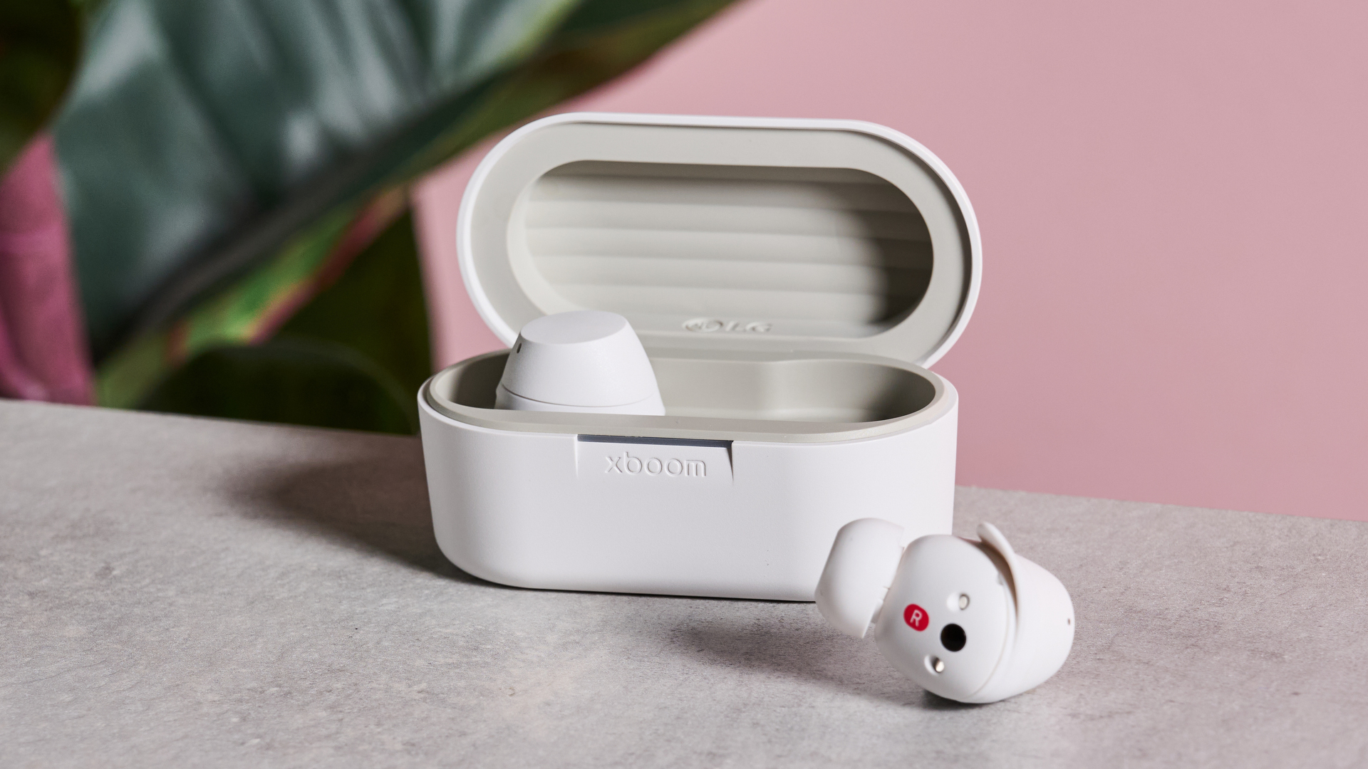 LG xboom Buds on surface with right earbud out of the charging case