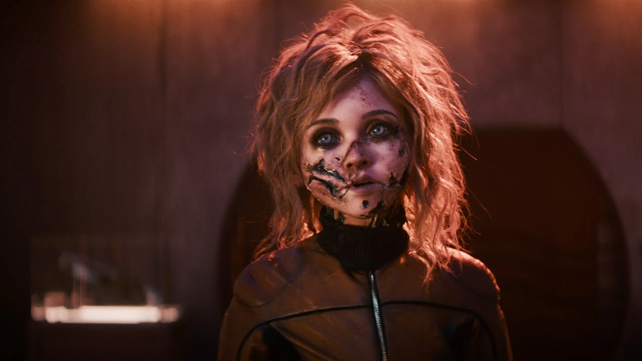 wxdjggkvck4dozfzbmekiz-1-13 The android M3GAN with messy hair and scratch marks all over her face after a fight